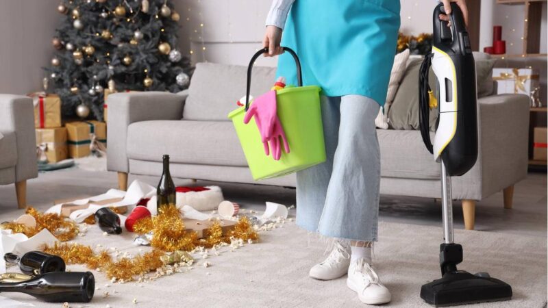 Una donna spruzza un deodorante naturale in un soggiorno dopo una festa.