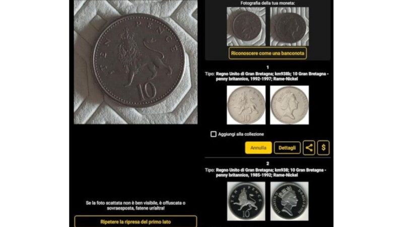 Persona che esamina attentamente una moneta antica con una lente d'ingrandimento su un tavolo.